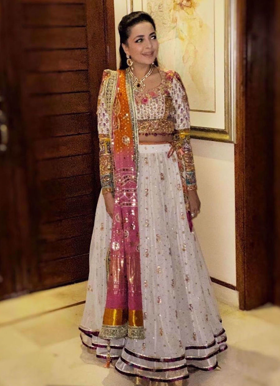 Our creative director Maliha Aziz Jamil, looks absolutely gorgeous in a stunning ivory lehnga choli accentuated with a signature #FarahTalibAziz chunri chaddar in shades of burnt orange and magenta
