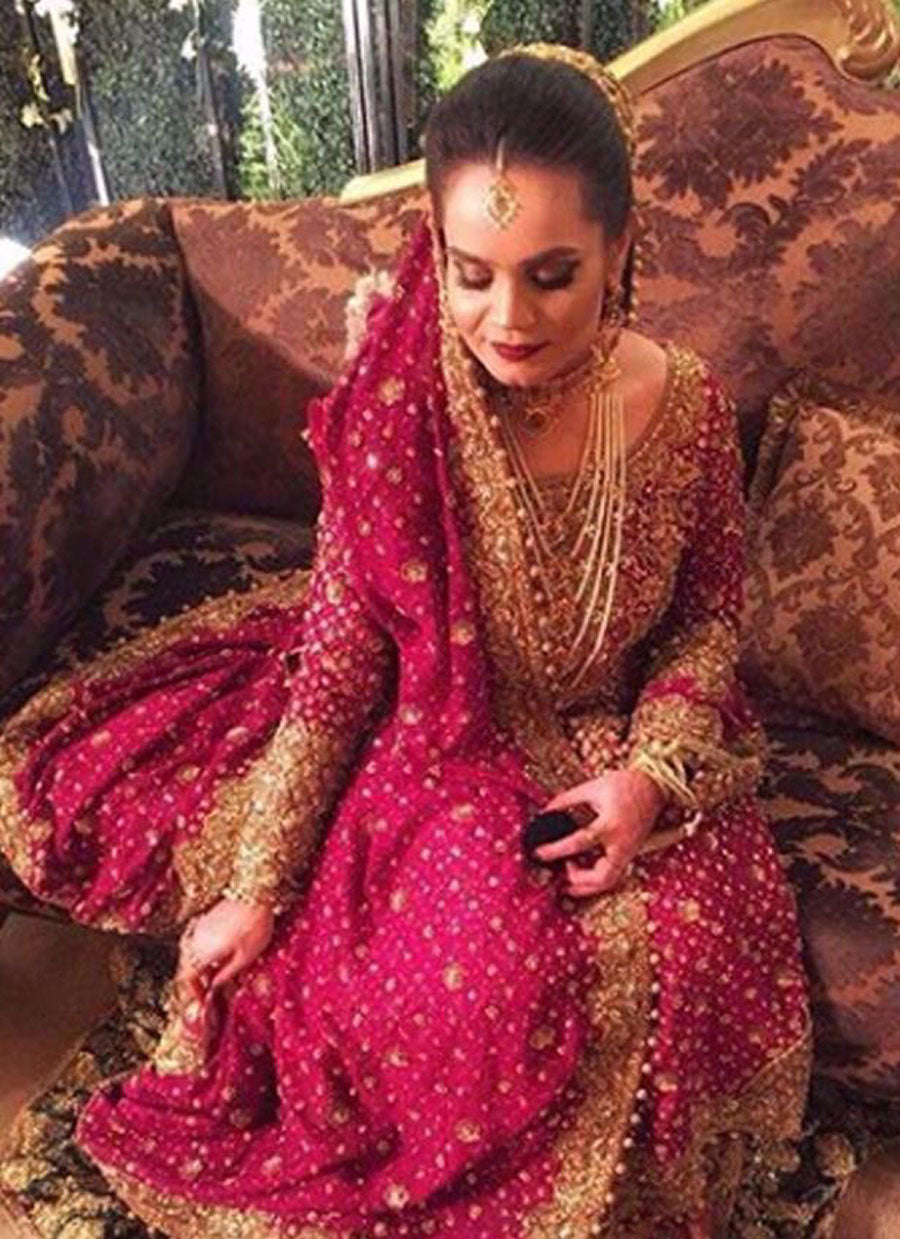 Sarah, traditionally regal in an anaar red and emerald green Farah Talib Aziz bridal