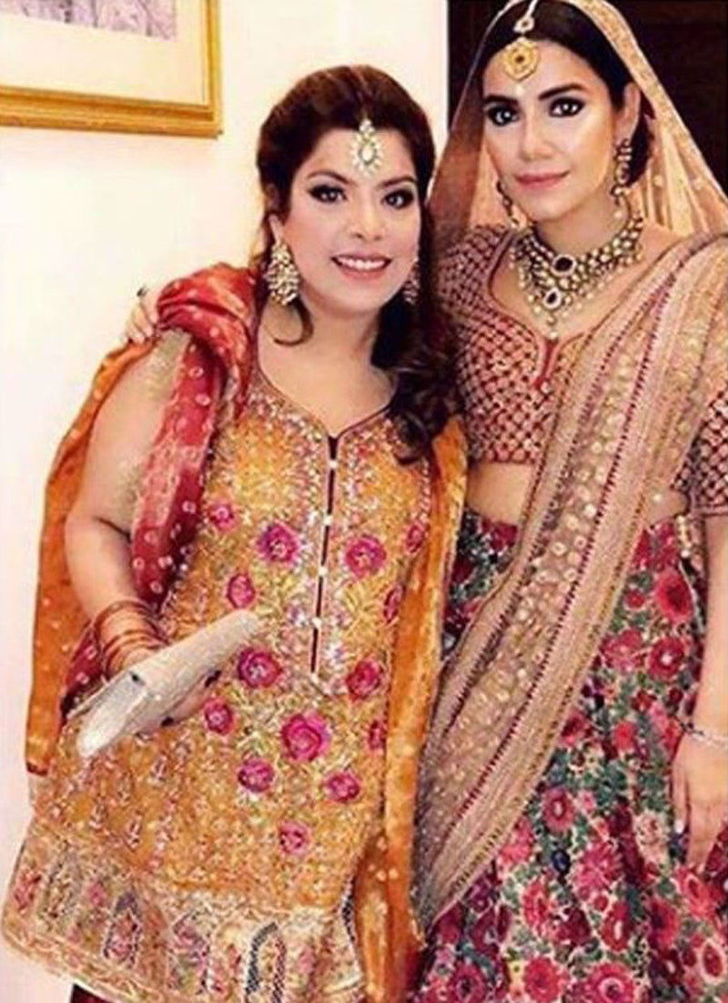 Eesha Hussain uber festive in a burnt orange and scarlet red Farah Talib Aziz ensemble